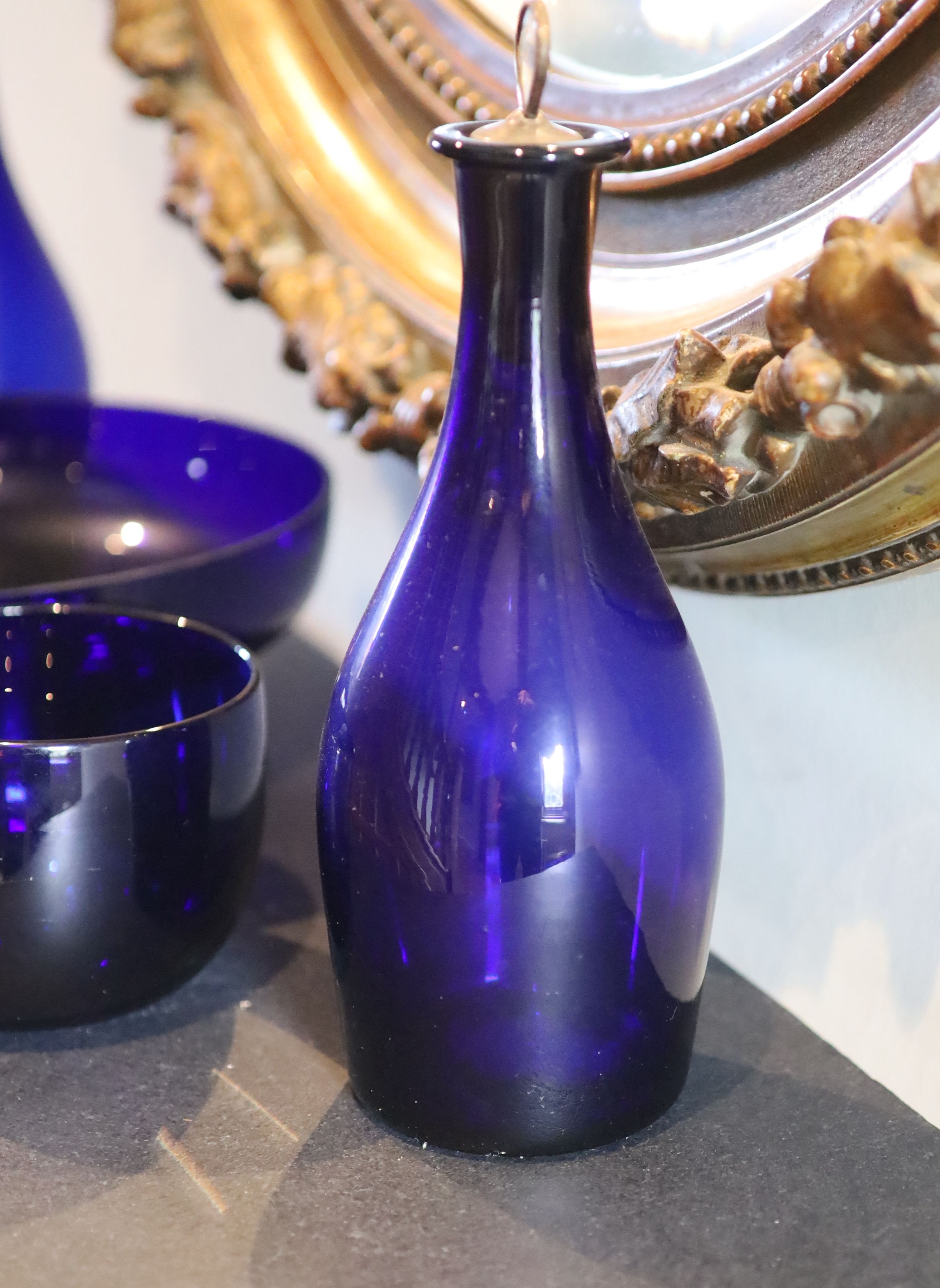 A pair of Bristol blue glass decanters with mother of pearl stoppers, height 28cm, a bowl, diameter 25cm and a finger bowl, diameter 12cm